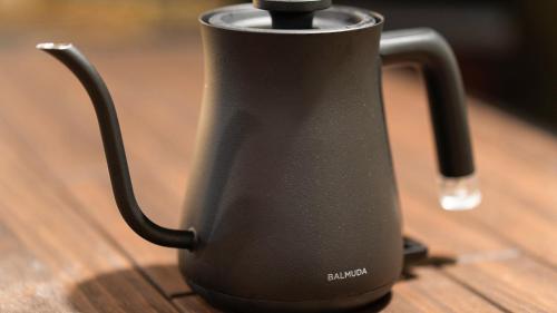 a black kettle sitting on top of a wooden table at Shiori in Kyoto
