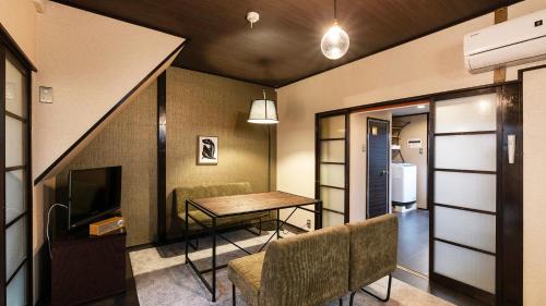 a living room with a table and chairs and a television at Shiori in Kyoto