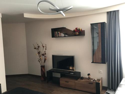 sala de estar con TV de pantalla plana y ventilador de techo en Viktoria Paradise, en Devin