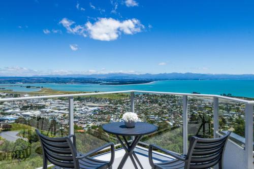 a balcony with a table and chairs and a view of a city at Tasman Bay Villa in Nelson