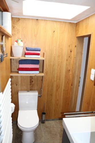 a bathroom with a toilet and a stack of towels at Pechhof in Innsbruck