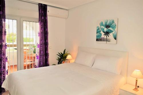 a bedroom with a white bed and a window at FABULOUS 2 BED 2 BATH APARTMENT ! in Villamartin