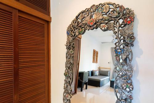 a large mirror hanging on a wall in a room at Moon Cottage in Choeng Mon Beach