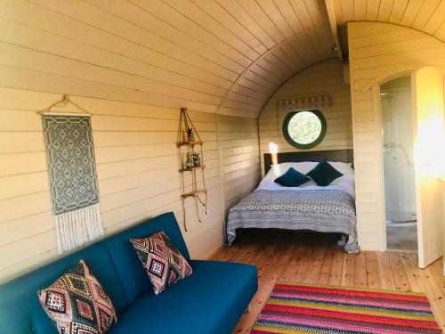 - une chambre avec un lit et un canapé dans l'établissement Rural self contained cosy pod house., à Garway
