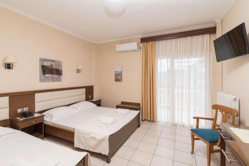 a hotel room with a bed and a table and chairs at Gold Stern in Paralia Katerinis