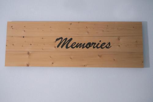 a wooden sign with the word memories on a wall at Κastro Ηotel in Agios Kirykos