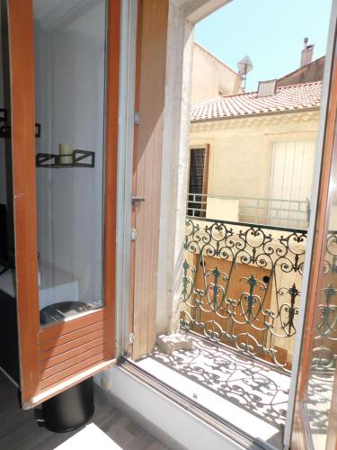 une fenêtre ouverte avec vue sur un balcon dans l'établissement Appartement tout équipé à 15 min des plages, à Béziers