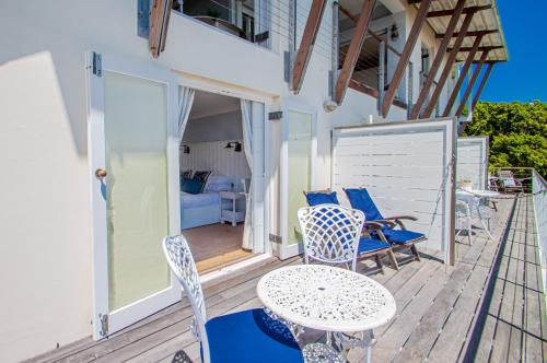 a patio with a table and chairs on a deck at A Boat House in Simonʼs Town