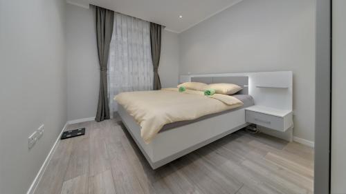 um pequeno quarto com uma cama e uma janela em Apartman Nostra em Zagreb