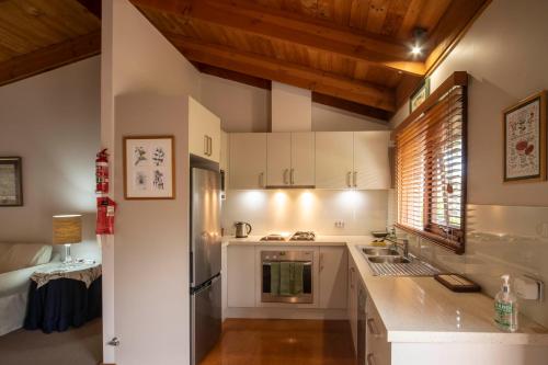 a kitchen with white appliances and wooden ceilings at The Studio Armidale in Armidale