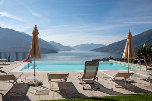 a swimming pool with chairs and umbrellas at Residence CaFelicita - Apartments Lake View - Infinity Pool - Jacuzzi in Gravedona