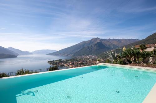 a swimming pool with a view of a body of water at Residence CaFelicita - Apartments Lake View - Infinity Pool - Jacuzzi in Gravedona