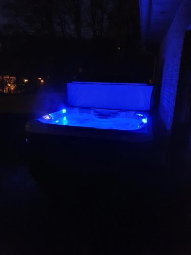 a hot tub with blue lights in the dark at Villa de la Sablière in Amougies