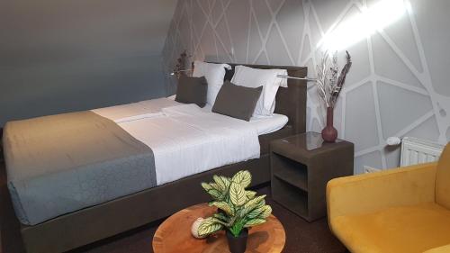 a bedroom with a bed and a chair and a table at De Eenhoorn in Oostburg