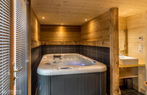 een badkamer met een bad en een wastafel bij LE QUARTZ DES HAUTES-VOSGES in Xonrupt-Longemer