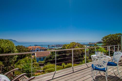 a balcony with chairs and a view of the ocean at A Boat House in Simonʼs Town