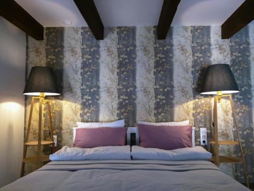 a bedroom with a large bed with two lamps at Freedom Square Studios in Tbilisi City