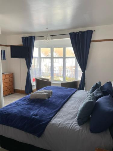 a bedroom with a large blue bed with blue pillows at Whiteways Guest House in Skegness