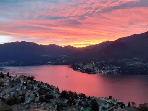 a view of a city and a lake at sunset at La Terrazza di Casarico in Moltrasio
