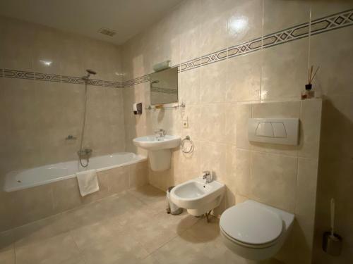 y baño con aseo, lavabo y bañera. en Hotel In Den Hoek, en Tielt