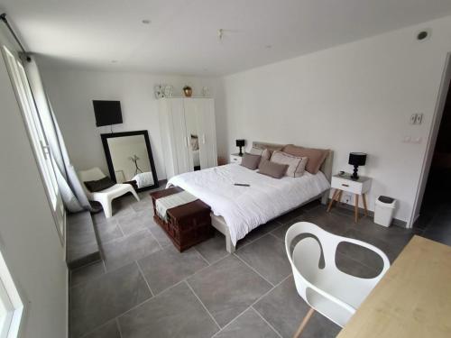 1 dormitorio con 1 cama, mesa y sillas en Chambre lit double, en Chambray-lès-Tours
