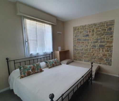 a bedroom with a large bed with a stone wall at Residenza Azzurra in Cattolica