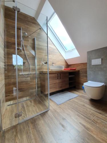 a bathroom with a glass shower and a toilet at Wilcza Dolina in Sękowa