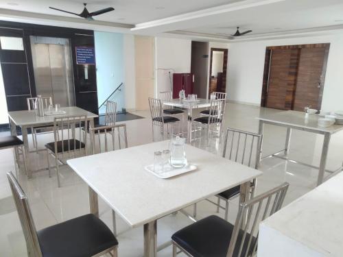 a dining room with tables and chairs and a kitchen at SERENE INTERNATIONAL in Bangalore