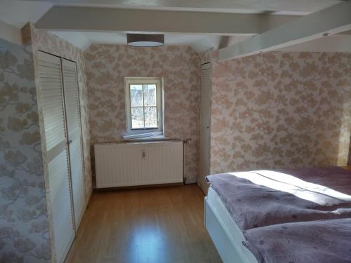 Gernrode - Harz的住宿－Ferienhaus Gero，一间卧室设有一张床和一个窗口