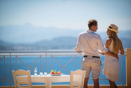 een man en een vrouw die naast een tafel staan bij Astoria Hotel in Agia Galini