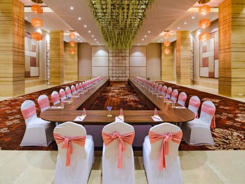 a long conference room with pink chairs and a long table at Sayaji Vadodara in Vadodara