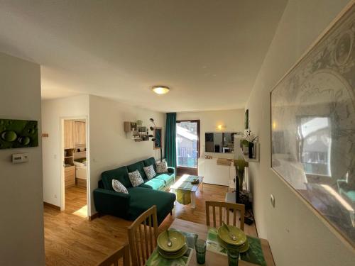 ein Wohnzimmer mit einem grünen Sofa und einem Tisch in der Unterkunft JARDINS DE RAMEL – APPT 2106*** - CURE/SKI WIFI in Luchon