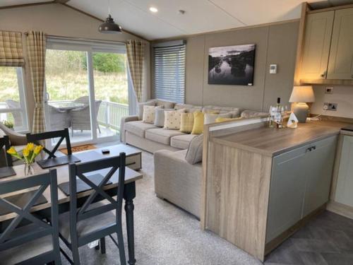 a kitchen and living room with a couch and a table at Honeybee Lodge in Morpeth