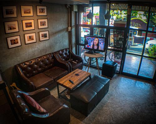 a living room with couches and a tv and a table at 84 Gallery in Chiang Mai