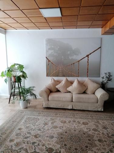 a living room with a couch and a painting of a bridge at Schöne Wohnung im Herzen von Burgstädt in Burgstaedt