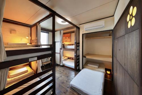 um pequeno quarto com 2 beliches em Sendai Guest House UMEBACHI em Sendai