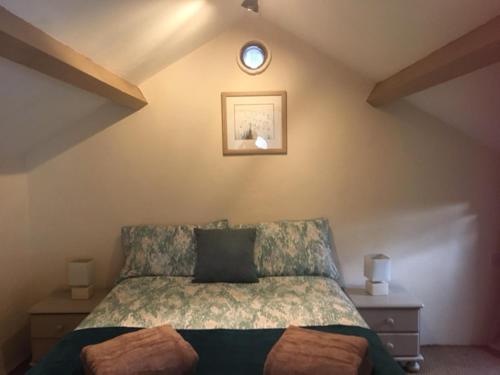 a bedroom with a bed and a clock on the wall at Cottage - Sleeps 4 - Pets Ok - Garden - Parking in Carnforth
