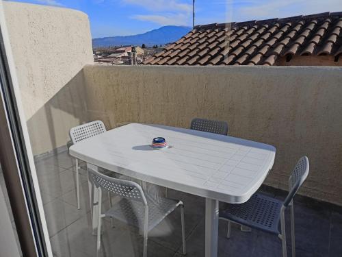d'une table et de chaises blanches sur un balcon. dans l'établissement Carpentras-Mont Ventoux, à Carpentras