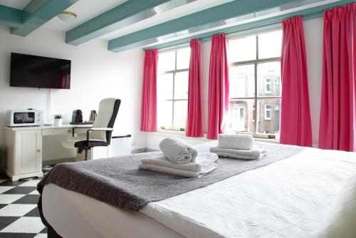 a bedroom with a large bed with towels on it at Modern Canal House Loft - City Center in Amsterdam