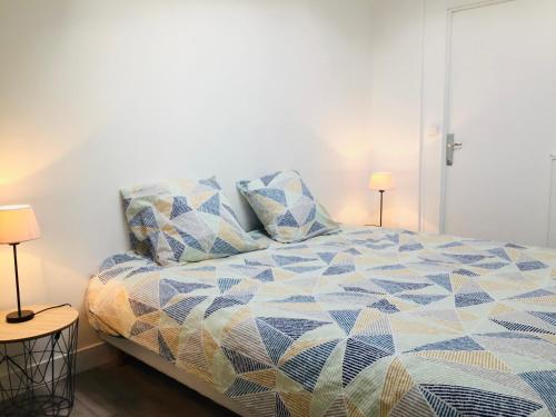 a bedroom with a bed and two lamps on tables at Chaleureux et spacieux appartement de centre-ville - Lit King Size - NETFLIX in Cherbourg en Cotentin