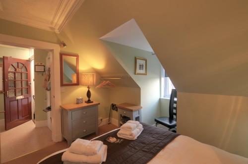 a bedroom with a bed and a desk and a chair at King Street Apartment in Inverness