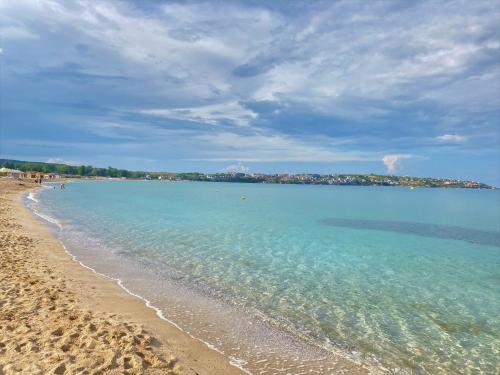 uma vista para uma praia com o oceano em art STUDIO in Green Live beach resort - at ground floоr with Terrace and green patio just infront ot the Pool em Sozopol