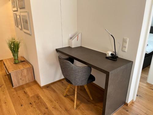 einen schwarzen Schreibtisch mit Stuhl in einem Zimmer in der Unterkunft Neues Traunsee Apartment Altmünster in Altmünster