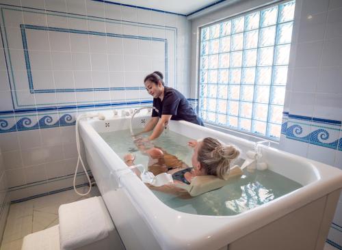 een vrouw en twee baby's in een bad bij The Cascades Golf Resort, Spa & Thalasso in Hurghada