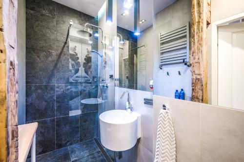a bathroom with a sink and a shower at Apartament Przy Żurawiu in Gdańsk