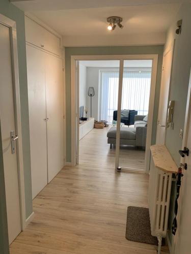 a hallway with a living room and a living room with a couch at Residentie Hippocampe in Wenduine