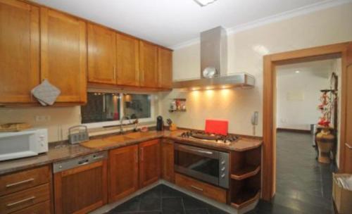 a kitchen with wooden cabinets and a stove top oven at Casa Ze da Cotta in Vila Verde
