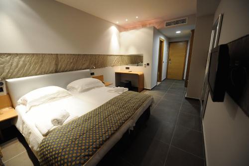 a hotel room with a large bed and a hallway at Hotel Iliana in Filippiada