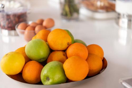 a bowl of oranges and apples and eggs on a counter at Makis Place in Tourlos