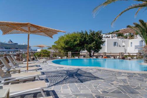 a pool at a resort with chairs and an umbrella at Makis Place in Tourlos